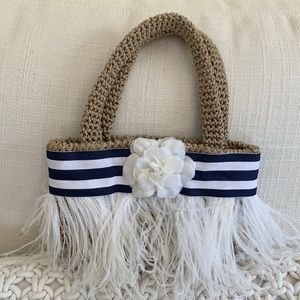 Girls woven bag with striped grosgrain ribbon, flower and feather detail.